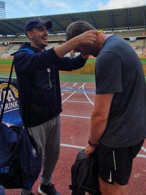 One team member places a medal over the head of another member after the conclusion of the Ekiden